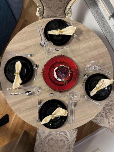 a table with plates and wine glasses on it at Stupine Gold in Tuzla