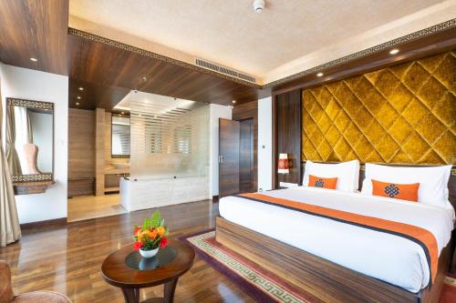a bedroom with a large bed and a table at Ramada by Wyndham Kathmandu Dhumbarahi in Kathmandu