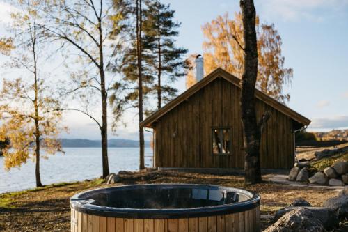 a bath tub in front of a log cabin at Hoel Gård - Herregården ved Mjøsa in Nes i Ådal