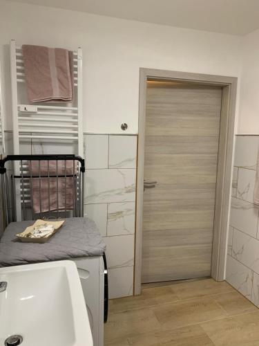 a bathroom with a bed and a door with a sink at Gemütliches Apartment in Bodenfelde in Bodenfelde