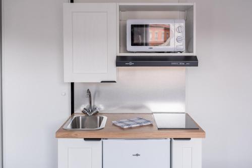 une cuisine avec un évier et un micro-ondes dans l'établissement Solaria - Logement Climatisée à Jean Jaurès, à Toulouse