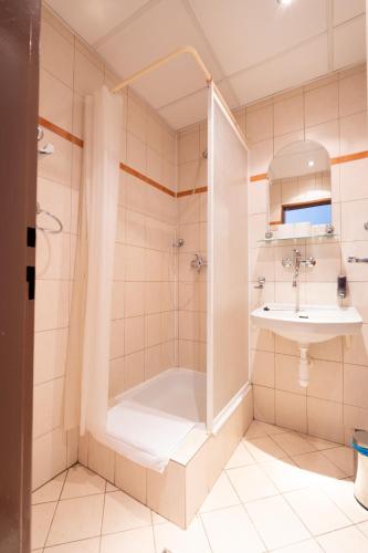 a bathroom with a shower and a sink at Hotel Slovakia in Žilina