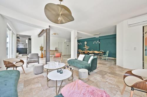 un salon avec un canapé vert et des tables dans l'établissement Villa avec piscine - 5 min d'Avignon, aux Angles (Gard)