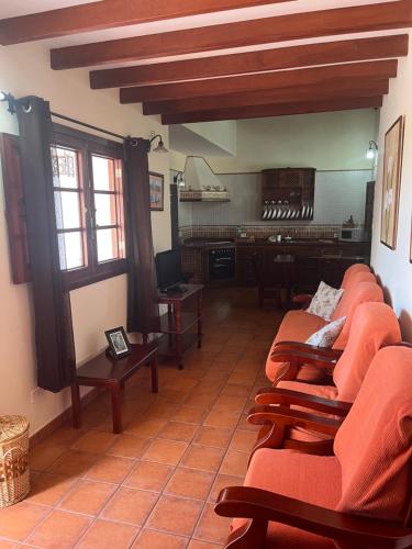a living room with orange chairs and a table at Casa Rural Antonio García - Terrace & BBQ, Hierro in Frontera