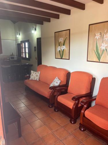 a waiting room with two orange chairs and a table at Casa Rural Antonio García - Terrace & BBQ, Hierro in Frontera