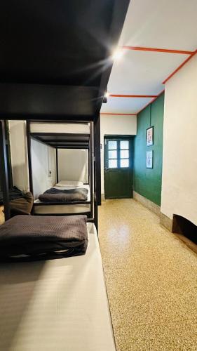 a room with two bunk beds and a green wall at Tentgram Plantation Hostel Suryanelli in Kottagudi