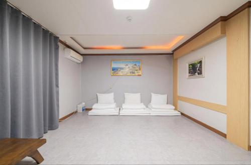 a room with white chairs and a curtain at Donghae Gloria Hotel in Donghae