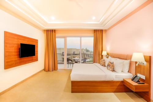 a hotel room with a bed and a balcony at Club Mahindra Patkote in Nainital