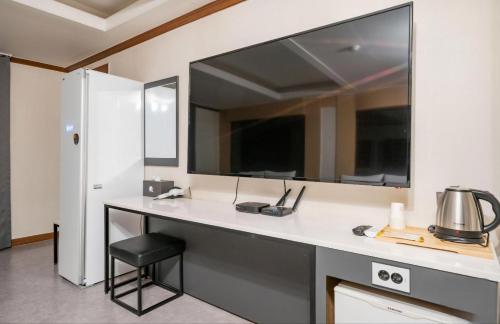 a bathroom with a counter with a sink and a mirror at Donghae Gloria Hotel in Donghae