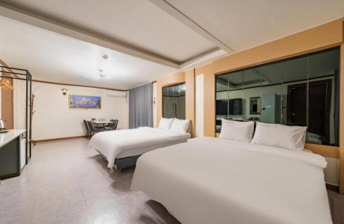 a hotel room with two beds and a table at Donghae Gloria Hotel in Donghae