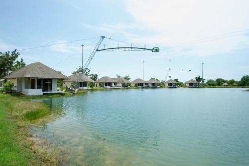 a large body of water with houses and a crane at Wake Park Cambodia in Siem Reap