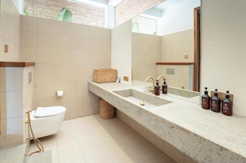 a bathroom with a sink and a toilet and a mirror at Wake Park Cambodia in Siem Reap