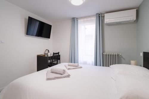 Un dormitorio con una cama blanca con toallas. en Wine & Four - Chambre Agréable sur les Allées, en Toulouse