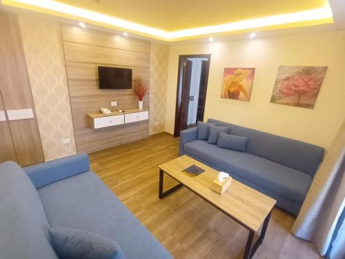a living room with a blue couch and a table at Batroun boutique suites in Batroûn