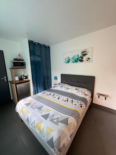 une chambre avec un lit avec une couette dessus dans l'établissement Chambre d'hôte, à Cucugnan