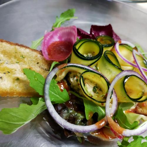 a plate of food with a salad and a sandwich at Hotel Les Alpes in Allevard