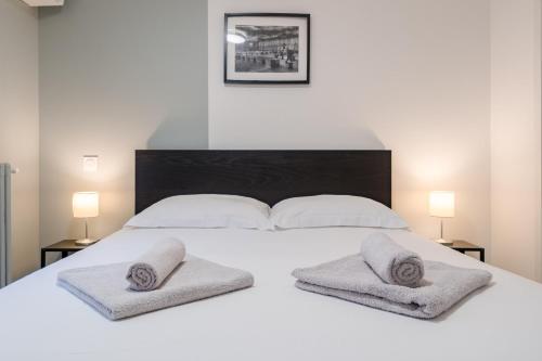 un grand lit blanc avec deux oreillers dessus dans l'établissement Aube Cachée - Chambre Calme au Coeur de Toulouse, à Toulouse