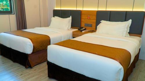 Ένα ή περισσότερα κρεβάτια σε δωμάτιο στο Vienna Hotel