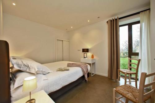 um quarto com uma cama, uma secretária e uma janela em Les Jardins du Porche em Sarlat-la-Canéda