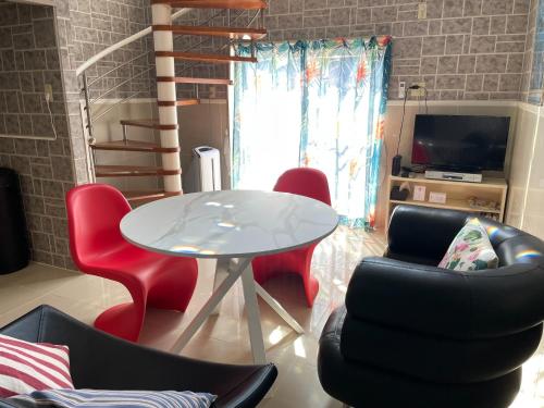 a living room with a white table and red chairs at Elegance Kukou Minami B - Vacation STAY 12934 in Miyazaki