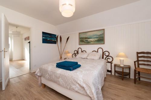 a bedroom with a bed with a blue towel on it at Maison de vacances esprit maritime in Damgan