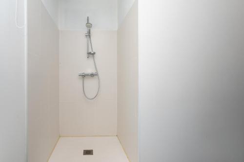 a shower in a white bathroom with a toilet at Maison de vacances esprit maritime in Damgan