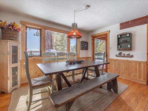 a dining room with a wooden table and a bench at JJs Lakeview Chalet in Tahoe Vista