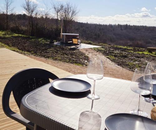a table with two wine glasses and a plate on it at Le Relais de D'Artagnan in Peyrusse-Grande