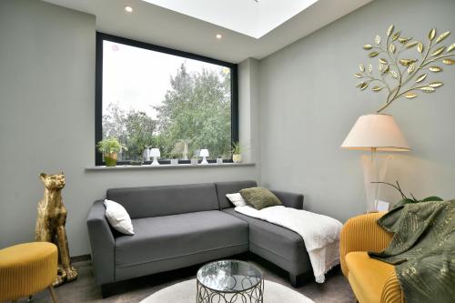 a living room with a couch and a window at Chez Marie-Céline - Maison avec jacuzzi à 20 min du Val André in Plestan