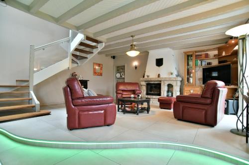 a living room with two chairs and a fireplace at Chez Marie-Céline - Maison avec jacuzzi à 20 min du Val André in Plestan