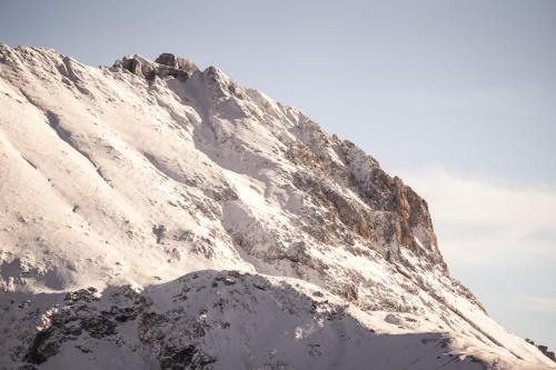 a snow covered mountain with the sky in the background at COMO Alpina Dolomites in Alpe di Siusi