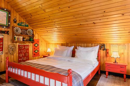 a bedroom with a bed in a wooden room at Casa cu Amintiri - Authentic Cozy Cottage in Bran