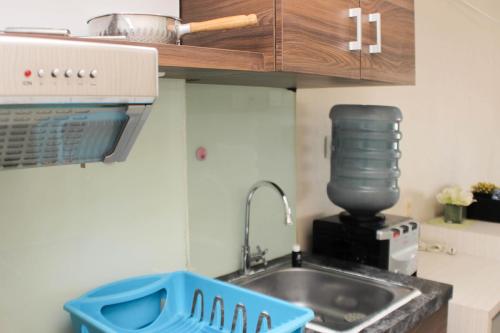 a kitchen counter with a sink and a mixer at Cozy Stay and Tranquil Studio Patraland Urbano Apartment By Travelio in Bekasi