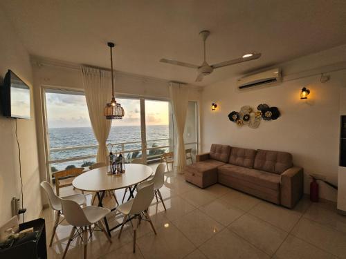 a living room with a table and a couch at Tropical Accommodations in Kandana