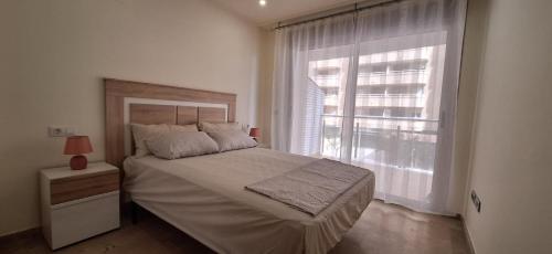 a bedroom with a bed and a large window at Marina d'Or Edificio Fase X - 1ª linea apartment in El Borseral