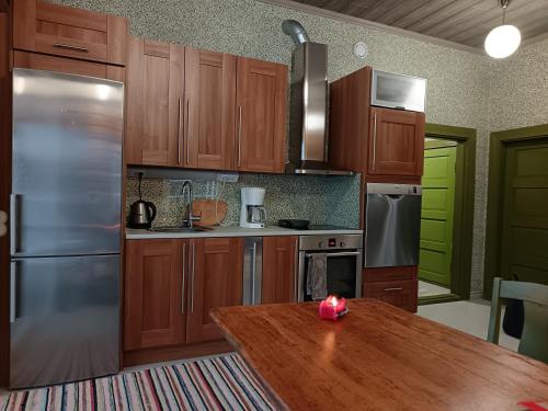 a kitchen with wooden cabinets and a wooden table at Lomalle in Vesiniemi