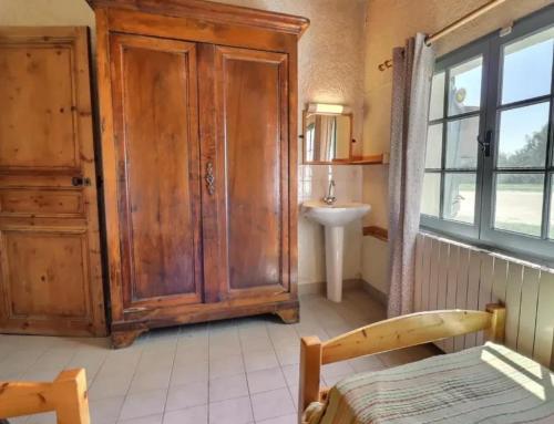 a bathroom with a wooden cabinet and a sink at Charmante maison en Camargue avec piscine partagée in Saintes-Maries-de-la-Mer