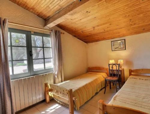 a bedroom with two beds and a window at Charmante maison en Camargue avec piscine partagée in Saintes-Maries-de-la-Mer