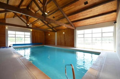 une grande piscine avec un plafond en bois dans l'établissement Maison charmante à Saintes-Maries-de-la-Mer avec piscine partagée, à Saintes-Maries-de-la-Mer
