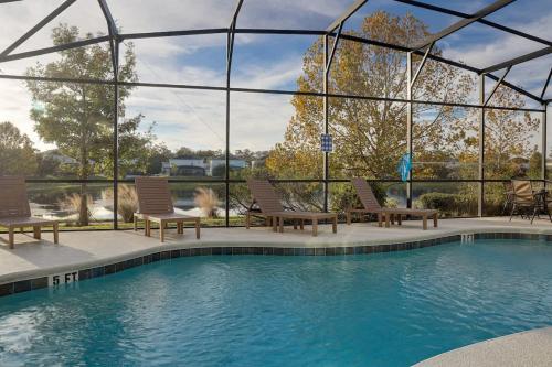 a swimming pool with two chairs at Sunny Stay in Orlando - 6BR Home with Pool! in Kissimmee