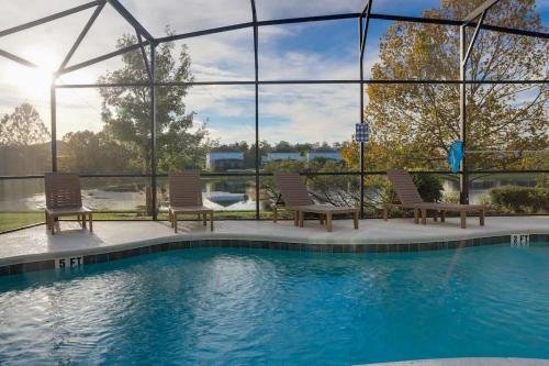 a swimming pool with two chairs and a pool at Sunny Stay in Orlando - 6BR Home with Pool! in Kissimmee