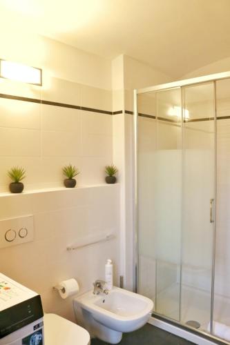 a bathroom with a shower and a toilet and a sink at Studio Red - by MyHomeInComo in Argegno