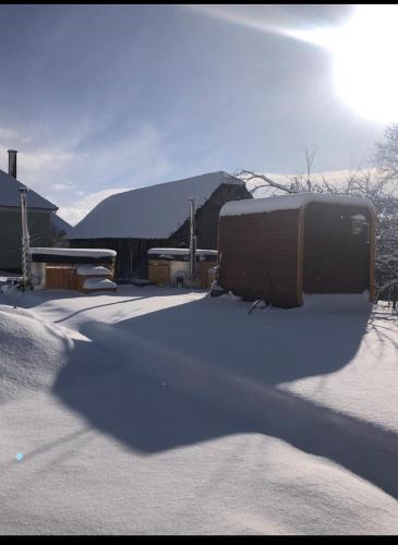 a snow covered yard with a bus parked in front of a house at Vass Panzio in Zălan