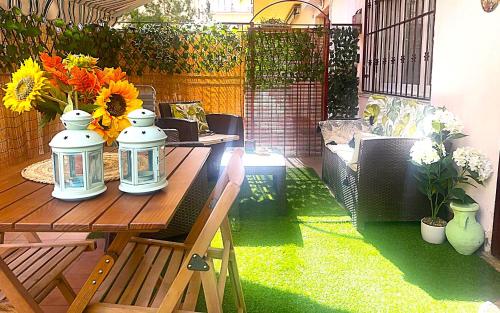 a patio with a wooden table with flowers on it at Residenza MIMOSA - in centro - in Sassari