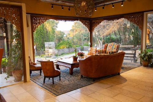 a living room with a couch and a table and chairs at Beit Oren Hotel in Bet Oren