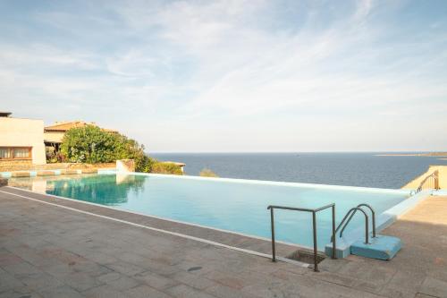 een zwembad met uitzicht op het water bij Le Dalie With Shared Pool - Happy Rentals in Marinella