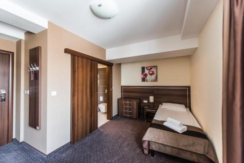 a hotel room with a bed and a desk at Hotel Austeria Conference & Spa in Ciechocinek