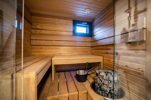 a wooden sauna with a bench and a bucket at Villa Alaska in Syöte