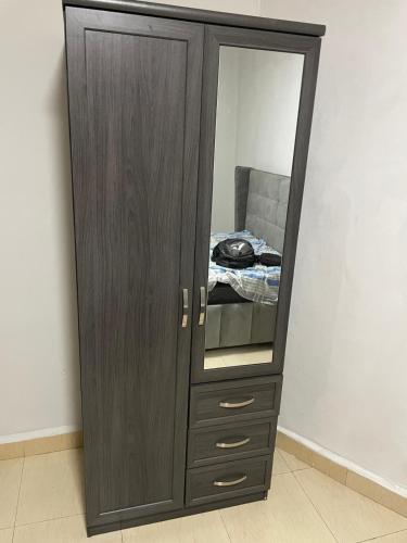 a wooden cabinet with a mirror in a room at Marongs Appartment in Djalabango