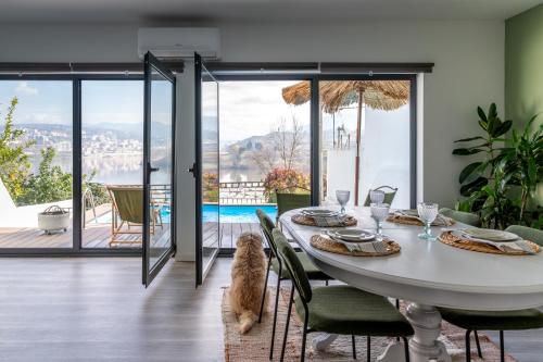 a dining room with a table with a cat sitting at it at Feel Discovery Casa DAlice in Peso da Régua